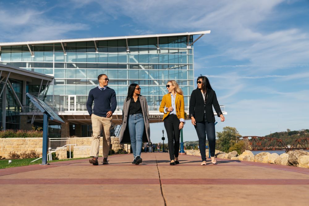 a group of four people walking along Dubuque, Iowa's riverwalk