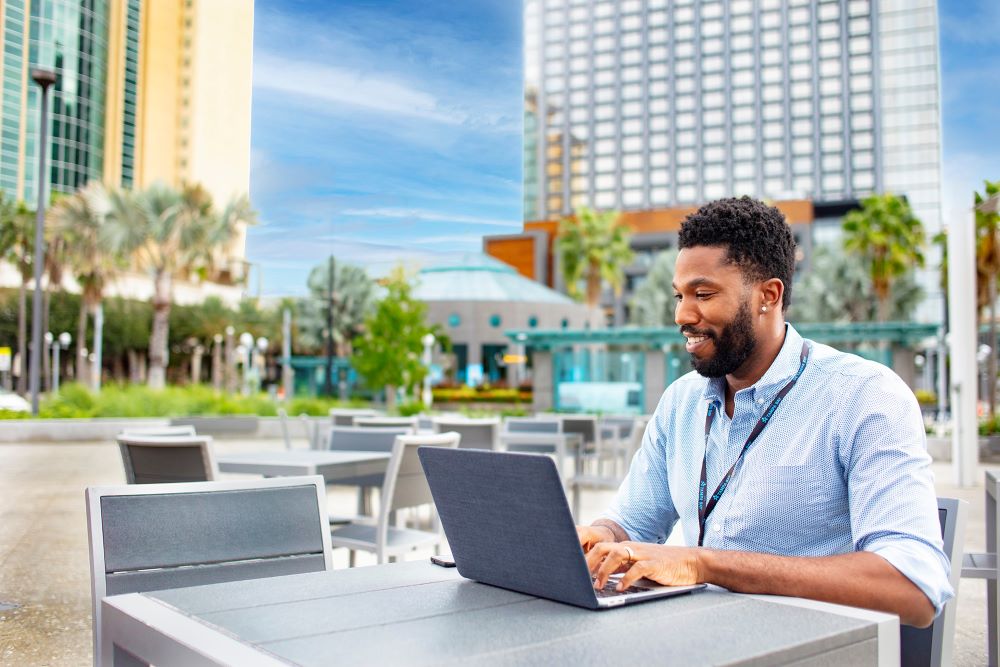 Man working on laptop outside in Tampa Bay