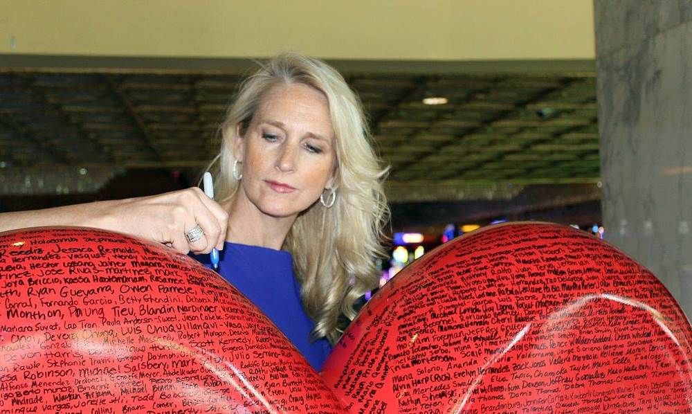 Cami Christensen signing the giant red heart