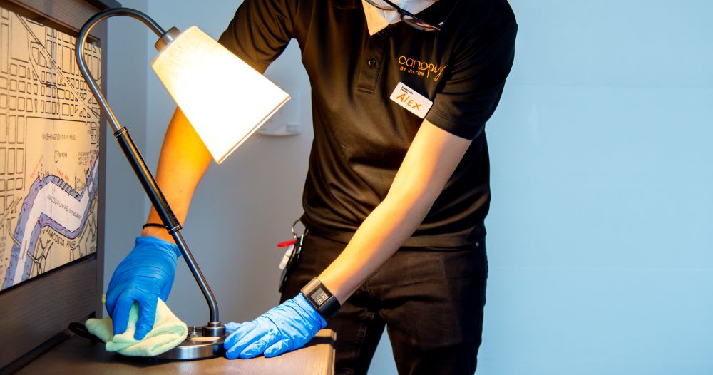 Employee cleaning guest room