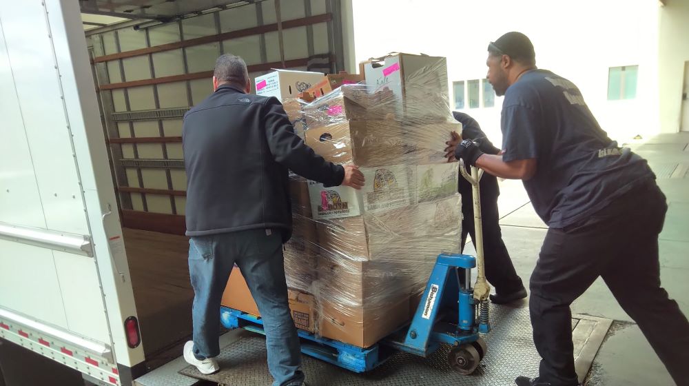 Workers pushing pallet of donations