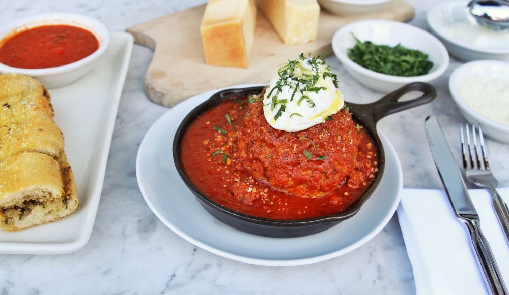 Very large meatball served in a cast iron pan