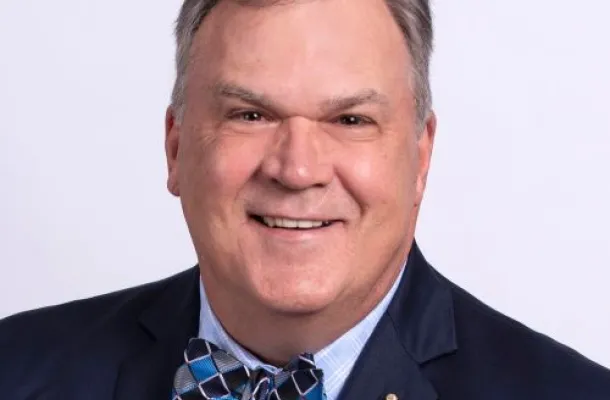 Roger Ricard in a dark blue suit with a checked bow tie.