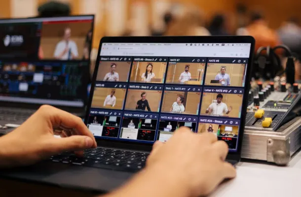 Image of two hands on a laptop, operating LiveSlides' NATE software system.
