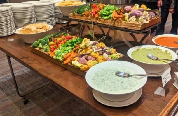 Photo of a serving table with a large selection of vegetables and dips.
