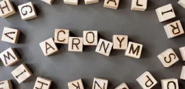 A photo of blocks in an array that spells out "acronyms"