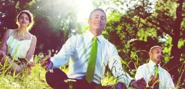 Graphic of business people in business attire meditating in a natural setting.