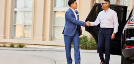 Photo of a Gaylord Hotels Celebrity Services staff member greeting a guest as he exits a black SUV.