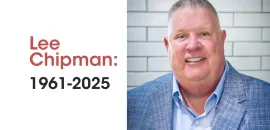Photo of Lee Chipman in a blue blazer in front of a white brick background
