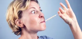 Image of a woman with a thermometer in her mouth.