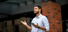 man wearing airpods and holding phone