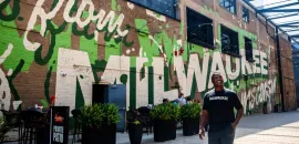 LeRoy Butler poses in front of a Milwaukee mural for Ask LeRoy. Credit: Visit Milwaukee