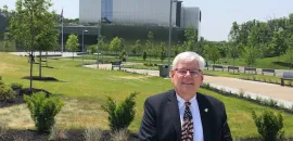 Dean Miller standing in the foreground of the National Museum of the United States Army.