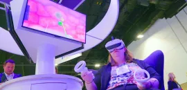 Photo of a woman wearing goggles to participate in a virtual reality activation.