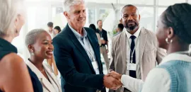 Photo of a person shaking another person's hand during a networking event.