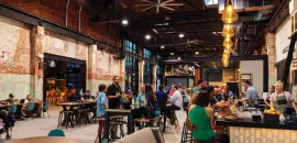 Armature Works food hall, with people sitting at a counter.