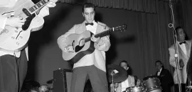 Elvis Presley performing on stage in the 1950s.