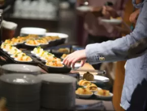 Person accessing a buffet table.