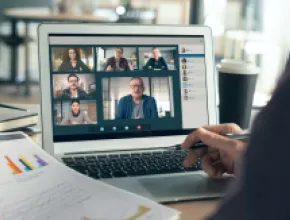 Hybrid events image of people in a virtual meeting on a laptop.