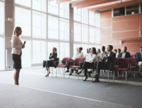 A woman talking to a room of seated people