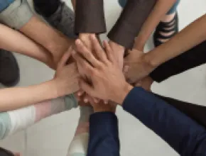Image of diverse arms locking hands in a circle.