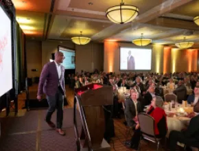 Meeting room full of attendees and a stage with a speaker in Lincoln, Nebraska