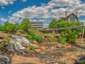 Photo of Reedy Falls and Liberty Bridge with Grand Bohemian Lodge Greenville in the background.