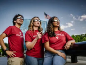 People looking up at the solar eclipse with eclipse glasses on. Photo Credit Cliff Ritchey and Visit Indy