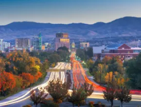 Photo of downtown Boise from a freeway with car lights.