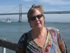 Photo of Maria Lenhart standing in front of the San Francisco Bay Bridge.