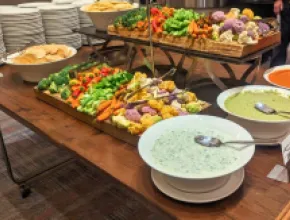 Photo of a serving table with a large selection of vegetables and dips.