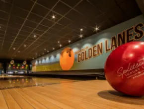 Photo of a red bowling ball in a bowling alley.