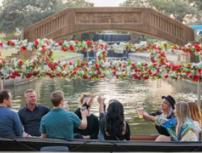 A group of people on a gondola toasting each other on Lake Carolyn.