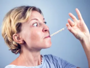 Image of a woman with a thermometer in her mouth.