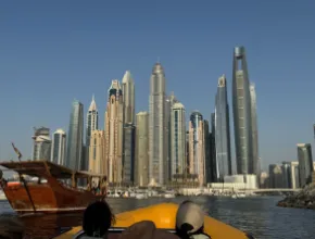 Photo of the skyline of Dubai from a boat on the water.