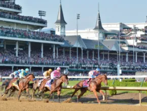 Photo of thoroughbred horses rounding at turn at Churchill Downs during the Kentucky Derby.