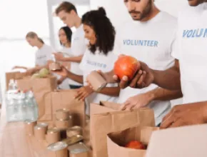 Stock photo of volunteers packing food bags.