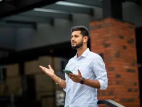 man wearing airpods and holding phone