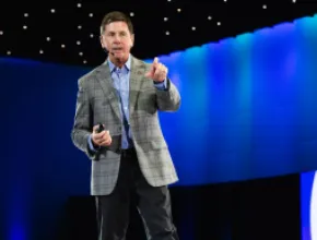 Photo of Steve O'Malley on stage, pointing at the audience.
