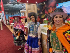 Peru booth at IMEX America 2025, with three women dressed in traditional Peruvian clothes.