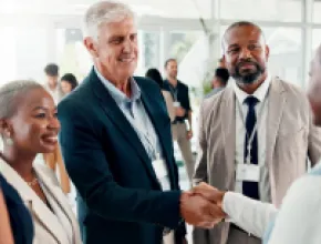 Photo of a person shaking another person's hand during a networking event.