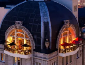 Rooftop balcony of The Bellevue Hotel at night.