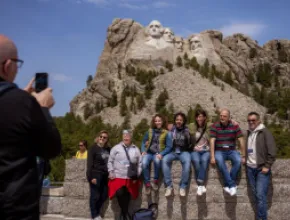 People posing for a photo in front of Mount Rushmore.