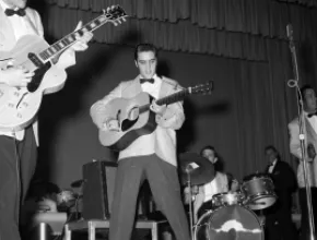 Elvis Presley performing on stage in the 1950s.