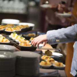 Person accessing a buffet table.