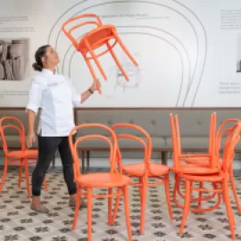 Chef Kaytlin Dangaran lifting a restaurant chair