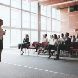 A woman talking to a room of seated people