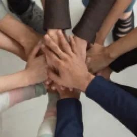 Image of diverse arms locking hands in a circle.