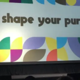 Photo of ASAE President and CEO Michelle Mason on stage at the association's annual conference, with the conference logo Shape Your Purpose on the screen behind her.