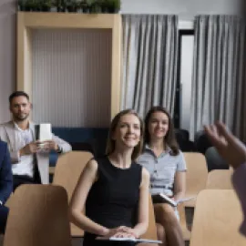 Group of people sitting in chairs listening to a speaker.